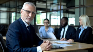 Directeur aan vergadertafel met drie andere leden van het team.