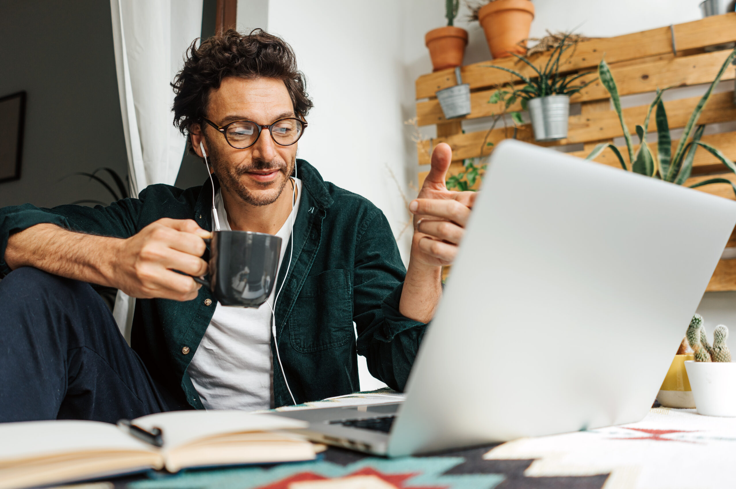 Freelancer achter een laptop met een bak koffie.